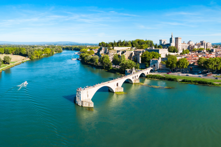 View of the Rhône River and the historic Pont d’Avignon near Flower Camping La Rivière in Provence, France.