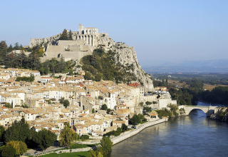 Vue sur Flower Camping La Rivière en Provence-Alpes-Côte d’Azur, France, avec rivière et château sur la colline.