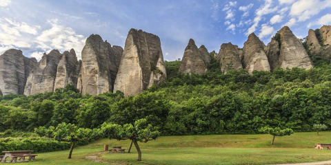 Dramatic rock formations rise above lush greenery at Flower Camping La Rivière in Provence-Alpes-Côte d’Azur, France.