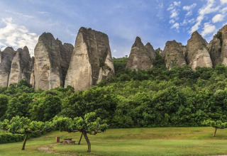 Dramatic rock formations rise above lush greenery at Flower Camping La Rivière in Provence-Alpes-Côte d’Azur, France.