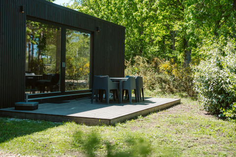 Ark Shelter naturhus med terrasse og havemøbler i grønne omgivelser ved De Klepperstee, Holland.