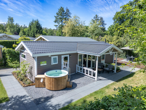 Wellness cottage with private hot tub and sauna at De Thijmse Berg in the Netherlands, set in greenery.