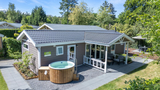 Cottage benessere con vasca idromassaggio privata e sauna a De Thijmse Berg, Olanda, immerso nel verde.