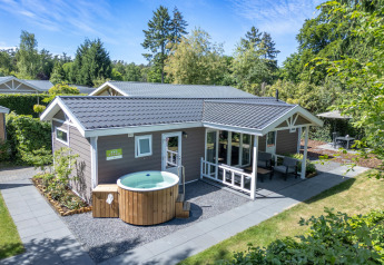 Cabaña wellness con jacuzzi y sauna privados en De Thijmse Berg, Países Bajos, rodeada de naturaleza.