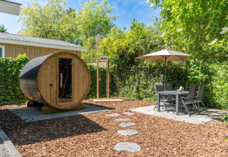 Jardin du Wellness Cottage à De Thijmse Berg, sauna privé, coin repas extérieur et verdure luxuriante.