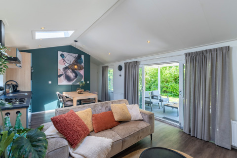 Chalet bien-être moderne à De Thijmse Berg, Pays-Bas, salon lumineux, coin repas, vue sur le jardin.