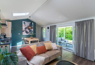 Chalet bien-être moderne à De Thijmse Berg, Pays-Bas, salon lumineux, coin repas, vue sur le jardin.