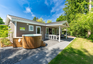 Wellness Cottage avec jacuzzi privé et sauna à De Thijmse Berg, Pays-Bas, entouré de verdure luxuriante.