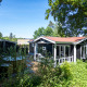 Wellness Lodge op De Thijmse Berg, Nederland, omgeven door groen en bomen onder een zonnige blauwe hemel.