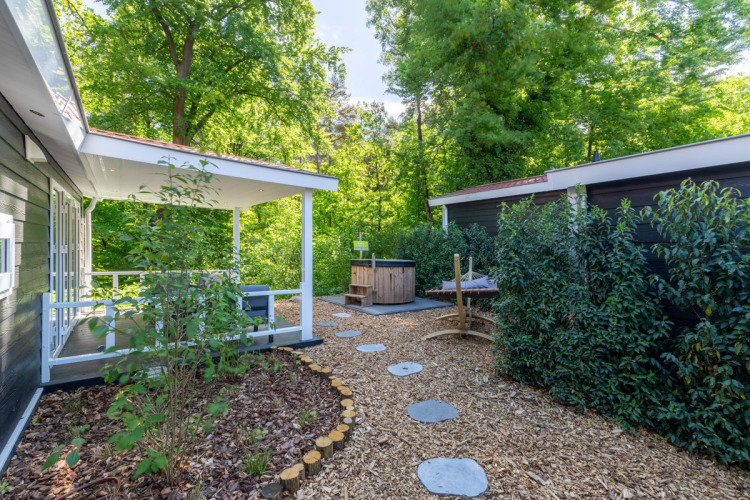 Außenbereich der Wellness Lodge bei De Thijmse Berg in den Niederlanden, umgeben von viel Grün.