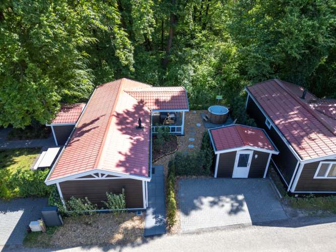 Luftaufnahme der Wellness Lodge in De Thijmse Berg, Niederlande, mit Whirlpool und üppigem Grün.