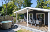 Familielodge met overdekt terras en hottub, omringd door natuur, bij De Thijmse Berg in Nederland.
