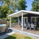 Lodge familial avec terrasse couverte et jacuzzi extérieur entouré d’arbres à De Thijmse Berg, Pays-Bas.