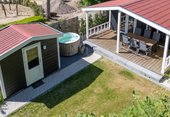 Bovenaanzicht van Family Lodge met hottub bij De Thijmse Berg in Nederland, met terras en tuin zichtbaar.