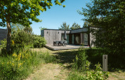 Casa de madera con terraza al aire libre y vegetación en Huus van Hanse, De Klepperstee, Países Bajos.