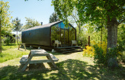 Casa tiny Wikkel en Holiday park De Klepperstee, Países Bajos, rodeada de árboles y zona verde.