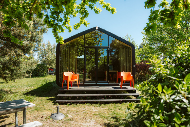 Casa moderna en la naturaleza en De Klepperstee, Oep, Países Bajos, rodeada de árboles verdes y naturaleza.