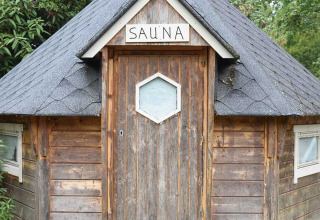 Houten saunahut met uithangbord, gefotografeerd bij Feather Down Het Boshuis vakantiepark in Gelderland, Nederland.