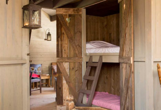 Knus interieur met houten stapelbedden en landelijke sfeer bij Feather Down Het Boshuis in Gelderland.