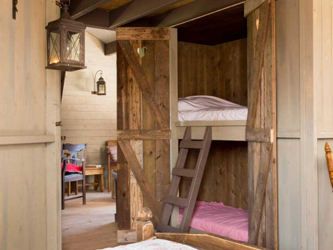 Interno accogliente con letti a castello in legno e dettagli rustici al Feather Down Het Boshuis, Gelderland.