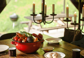 Verdure fresche e uova su un tavolo rustico con candele, fotografati a Feather Down Hilserhof, in Germania.