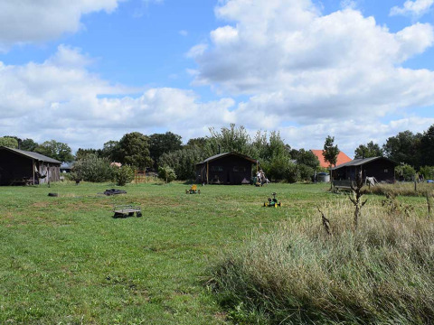 Vista del parque vacacional Feather Down De Kalverweide en Overijssel, Países Bajos, con cabañas y prados verdes.