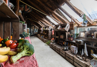 Binnenaanzicht van een boerderijwinkel bij Feather Down De Kalverweide met verse groenten en lokale producten.