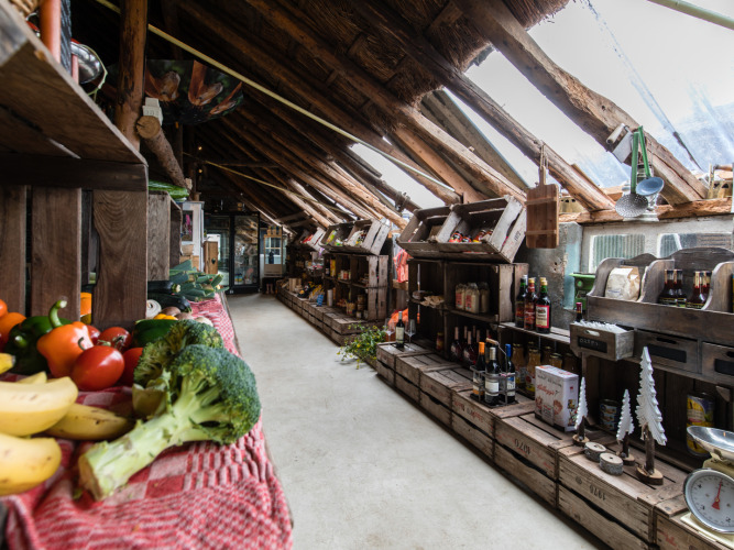 Binnenkant van een landelijke winkel bij Feather Down De Kalverweide met verse groenten en streekproducten.