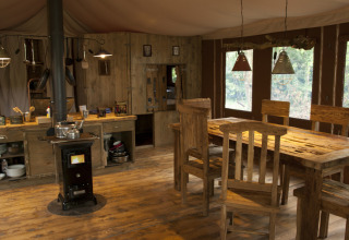 Indretning af rustik hytte på Feather Down Glastonbury Hill Farm med træmøbler og komfur.