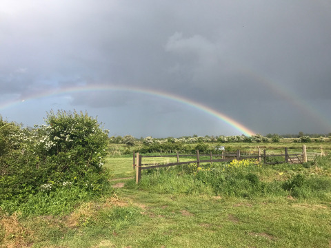 Doppio arcobaleno sui campi di Feather Down College Farm, parco vacanze nell’Est dell’Inghilterra, Regno Unito.