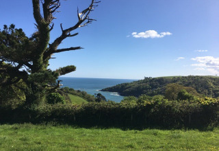 View of lush hills and coastline from Feather Down Fountain Violet Farm, South West England, United Kingdom.