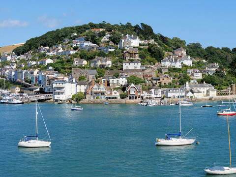 Vista panoramica di case colorate e barche nel porto di Feather Down Fountain Violet Farm, sud-ovest inglese.