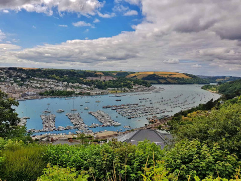 View of the river, marina, and lush valley from Feather Down Fountain Violet Farm in South West England.