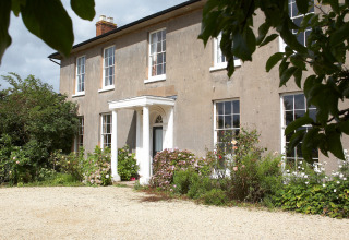 Feather Down Hollings Hill: Historic villa with garden, flowerbeds, and gravel path in West Midlands, UK.