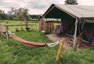 Glamping bei Feather Down Hollings Hill im West Midlands, Vereinigtes Königreich, mit Hängematte und Zelt.