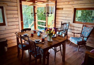 Rustieke houten eetkamer met gedekte tafel en bloemenboeket bij Warren Farm vakantiepark, Engeland.