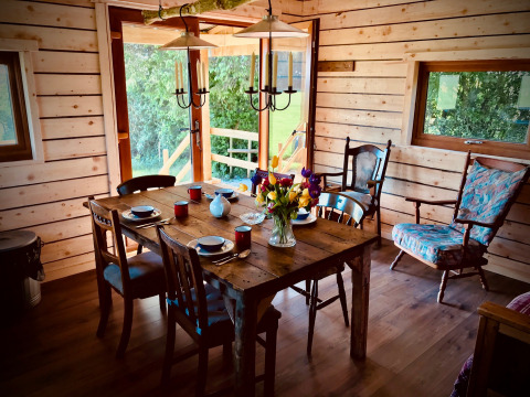 Rustieke houten eetkamer met gedekte tafel en bloemenboeket bij Warren Farm vakantiepark, Engeland.