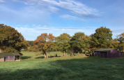Billede af Feather Down La Ferme de Penquelen Huella feriepark i Bretagne, Frankrig med telte og grønne marker.