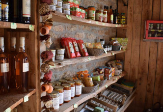Scaffali rustici con cibi locali, vini e conserve a Feather Down La Ferme de Penquelen Huella in Bretagna, Francia.