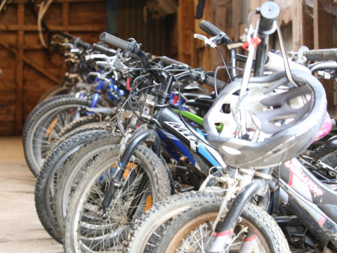 Plusieurs vélos rangés à l’intérieur, un casque au guidon à New Barn Farm, Est de l’Angleterre.