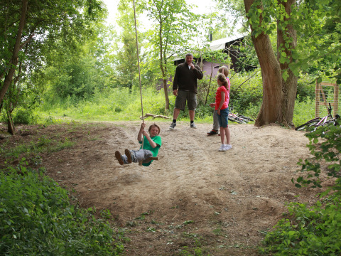 Des enfants jouent sur une balançoire en corde à Feather Down New Barn Farm, parc de vacances en Angleterre de l'Est.