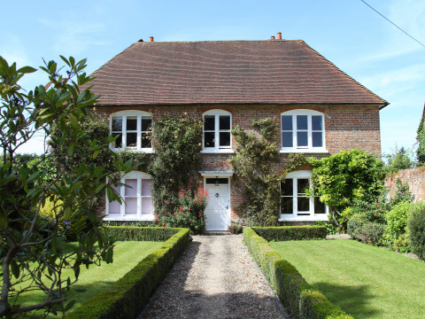 Groot landhuis met bakstenen gevel en verzorgde tuin bij Feather Down Manor Farm, Zuidoost-Engeland.