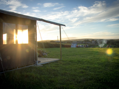 Atardecer sobre un campo en Feather Down Treganhoe Farm, un parque vacacional en el suroeste de Inglaterra, Reino Unido.