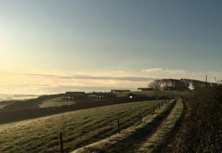 Udsigt til Feather Down Treganhoe Farm, en feriegård i det sydvestlige England ved solopgang.