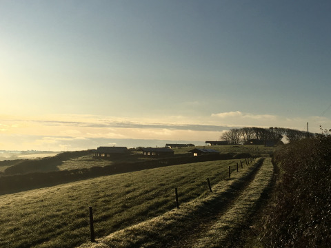Vista di Feather Down Treganhoe Farm, un villaggio vacanze nel sud-ovest dell’Inghilterra all’alba.