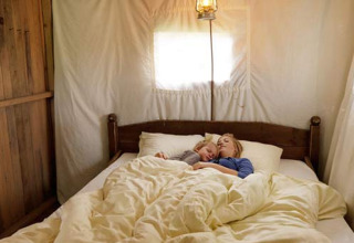Twee personen slapen knus samen in bed bij Feather Down L'Étable des Mauges en Anjou in Frankrijk.