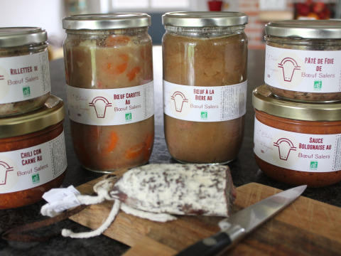 Barattoli di prodotti di manzo Salers e paté su un tavolo a L'Étable des Mauges, Pays de la Loire.