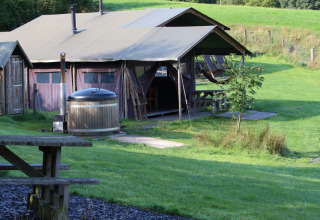Glamping telt med terrasse, udekøkken og jacuzzi på Feather Down Pant y March Farm i Wales, Storbritannien.