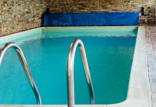 Indendørs swimmingpool med metal gelænder ved Feather Down Moor Farm, feriested i det sydvestlige England.
