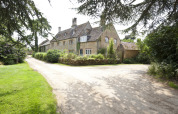 Stort landsted omgivet af grønne områder på Feather Down Hidcote Manor Farm, feriepark i West Midlands, UK.